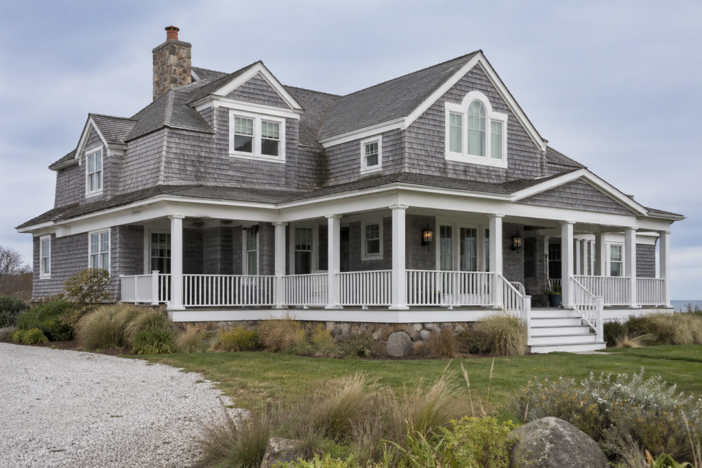 Pewter green coastal shingle home with white trim and light gray stone foundation near the beach 