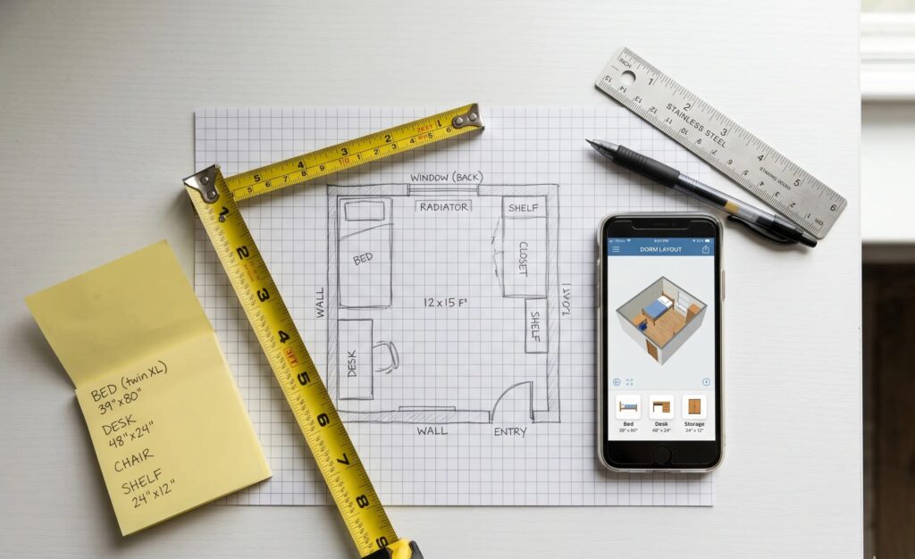 planning a dorm room setup with floor plan sketch and tape measure 