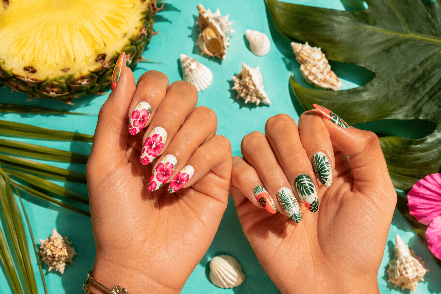 tropical nail ideas 2026 — hibiscus and palm leaf nail art on almond nails flat lay