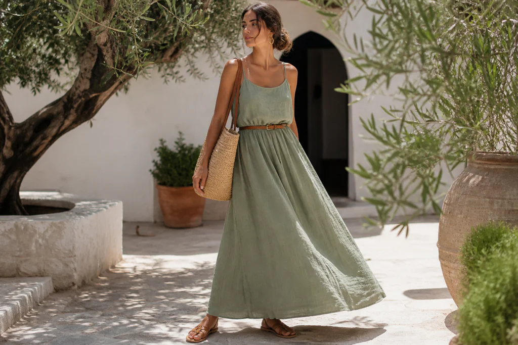 linen outfits for women 2026 — sage green linen maxi dress belted at waist with sandals and straw bag