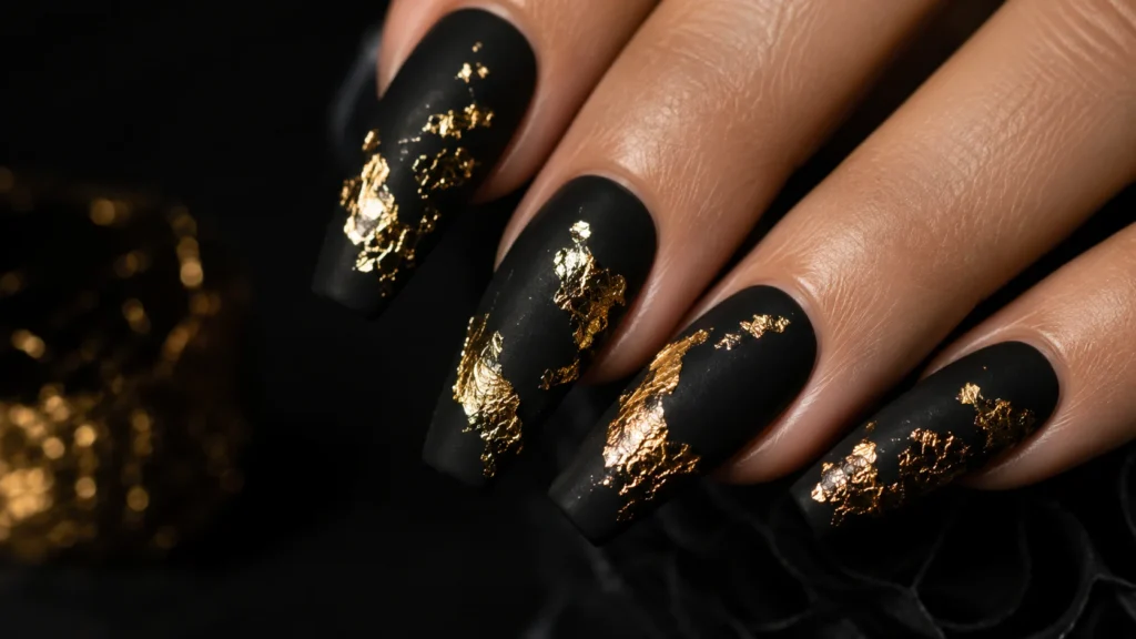 black nail ideas with gold foil art on coffin nails editorial style